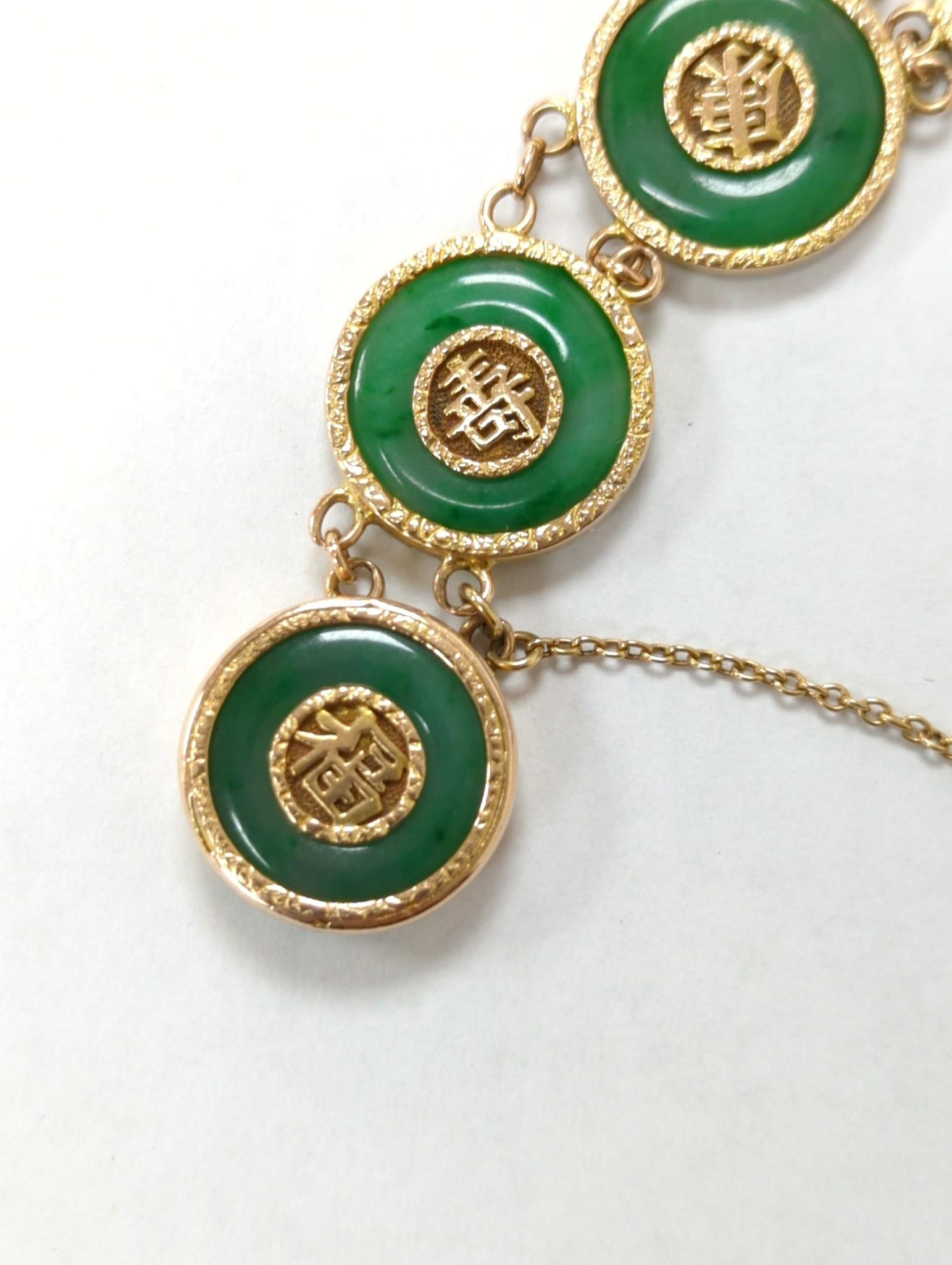 A Chinese yellow metal (stamped 18) and pierced eight stone jade disc set bracelet, with central Chinese characters, 16.5cm approx. gross weight 27.7 grams.